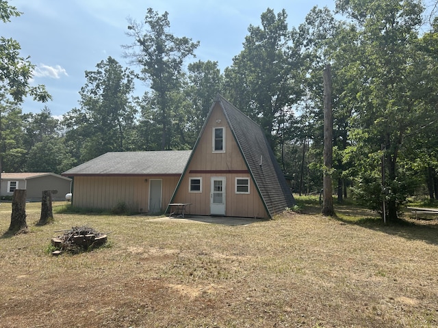 3423 S James Rd, Baldwin, MI 49304 - back of property with a fire pit and view of wooded area
