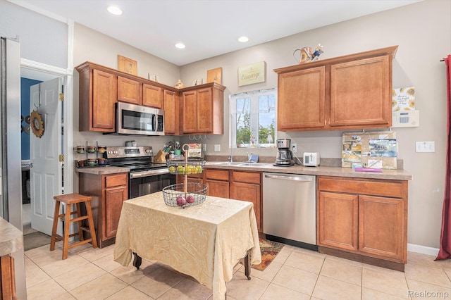 5304 Boomerang Cir, Newport, MI 48166 - kitchen with stainless steel appliances, brown cabinets, light tile patterned flooring, light countertops, and recessed lighting