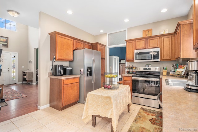 5304 Boomerang Cir, Newport, MI 48166 - kitchen with stainless steel appliances, light countertops, brown cabinets, light tile patterned floors, and recessed lighting