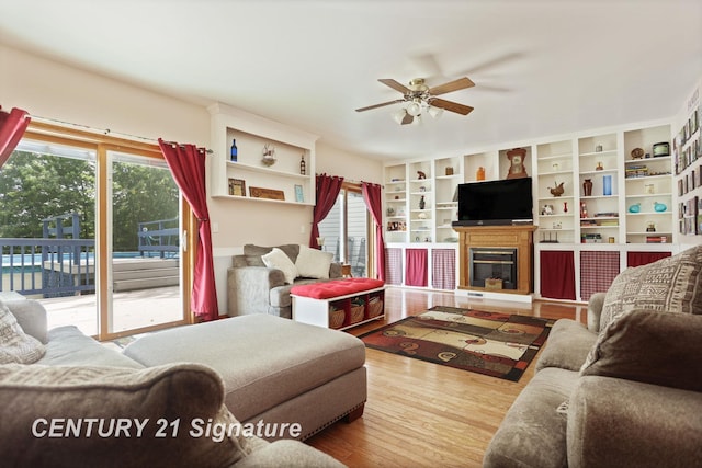 3405 S Miller Rd, Saginaw, MI 48609 - living room with a ceiling fan, wood finished floors, and a glass covered fireplace