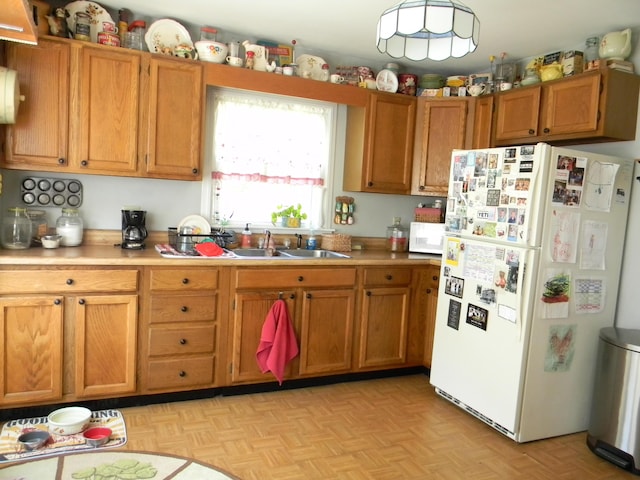 103 S Staffon St, Ludington, MI 49431 - kitchen with white appliances, light countertops, and brown cabinetry