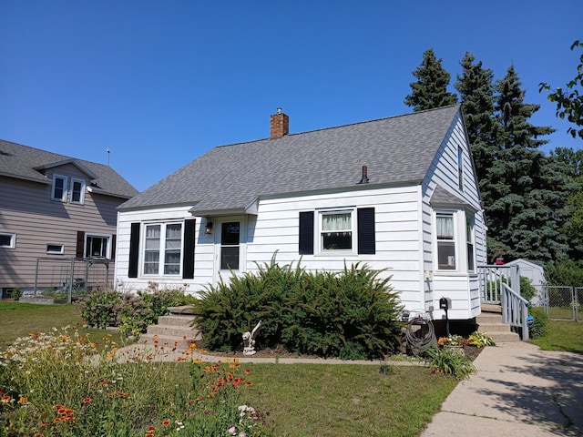 103 S Staffon St, Ludington, MI 49431 - view of front of home featuring a chimney and roof with shingles
