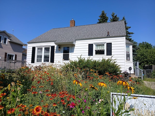 103 S Staffon St, Ludington, MI 49431 - view of front facade featuring a chimney and a shingled roof