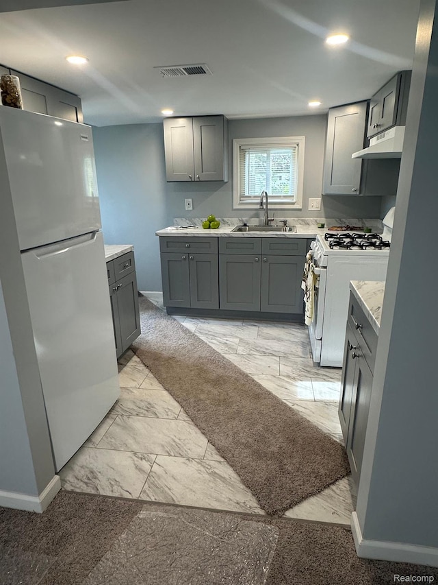 17788 Quarry St, Riverview, MI 48193 - kitchen with freestanding refrigerator, gray cabinetry, white range with gas cooktop, under cabinet range hood, and recessed lighting