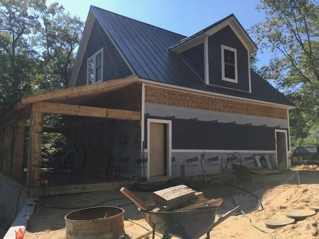 777 W Lincoln Ave, White Cloud, MI 49349 - view of property exterior featuring a metal roof, a patio area, and a fire pit