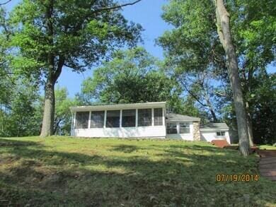 777 W Lincoln Ave, White Cloud, MI 49349 - view of front facade with a sunroom and a front lawn