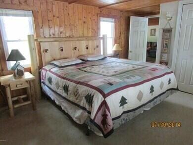 777 W Lincoln Ave, White Cloud, MI 49349 - carpeted bedroom featuring wooden walls and wood ceiling