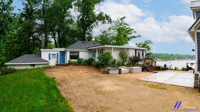 777 W Lincoln Ave, White Cloud, MI 49349 - rear view of house with a water view, a yard, and a patio