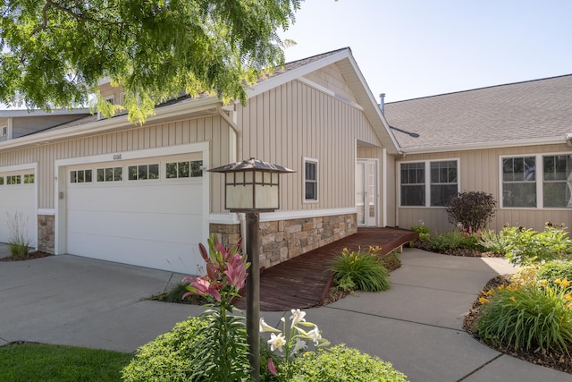 10068 S Crossroads Cir SE, Caledonia, MI 49316 - view of front of property featuring stone siding, concrete driveway, and roof with shingles