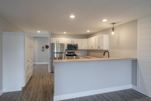 10068 S Crossroads Cir SE, Caledonia, MI 49316 - kitchen with stainless steel appliances, a peninsula, light countertops, dark wood-type flooring, and recessed lighting