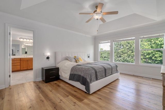 8375 Grapevine Circle, Cir, MI 49071 - bedroom featuring light wood-style floors, a tray ceiling, ornamental molding, ceiling fan, and connected bathroom