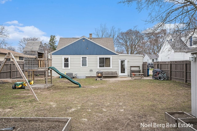 1314 Grant St, Grand Haven, MI 49417 - back of house featuring a playground, a fenced backyard, roof with shingles, a chimney, and a vegetable garden