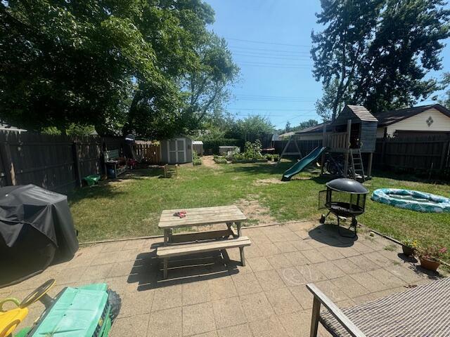 1314 Grant St, Grand Haven, MI 49417 - fenced backyard with a storage shed, a playground, a patio area, and area for grilling