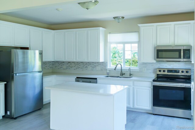 1803 Pinecroft Dr, Canton, MI 48188 - kitchen with appliances with stainless steel finishes, decorative backsplash, light countertops, light wood finished floors, and white cabinets