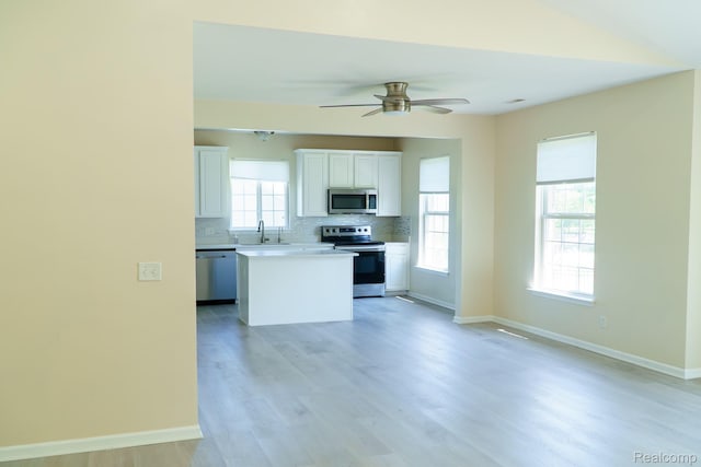 1803 Pinecroft Dr, Canton, MI 48188 - kitchen with stainless steel appliances, tasteful backsplash, a center island, light wood-style flooring, and white cabinets