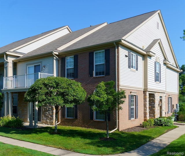 1803 Pinecroft Dr, Canton, MI 48188 - townhome / multi-family property with a front yard, stone siding, and a balcony