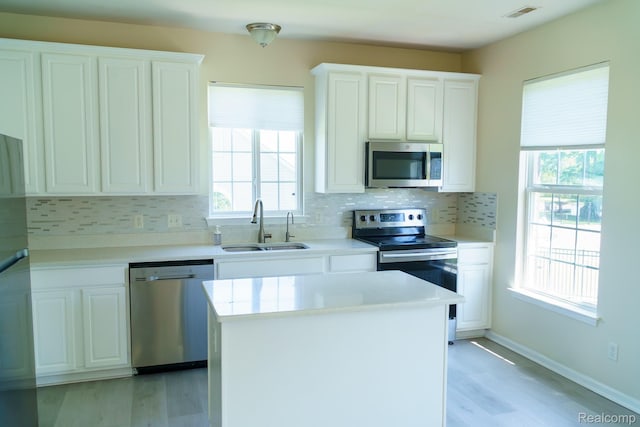 1803 Pinecroft Dr, Canton, MI 48188 - kitchen featuring appliances with stainless steel finishes, backsplash, white cabinets, and light wood-style floors