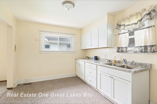 2249 N Clinton St, Saginaw, MI 48602 - kitchen featuring light colored carpet, white cabinets, and light countertops