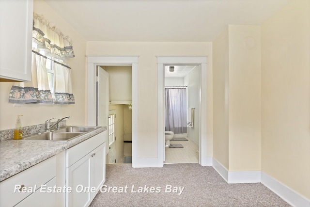 2249 N Clinton St, Saginaw, MI 48602 - kitchen featuring light carpet, white cabinetry, and light countertops