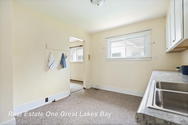 2249 N Clinton St, Saginaw, MI 48602 - kitchen with carpet flooring, white cabinets, and light countertops