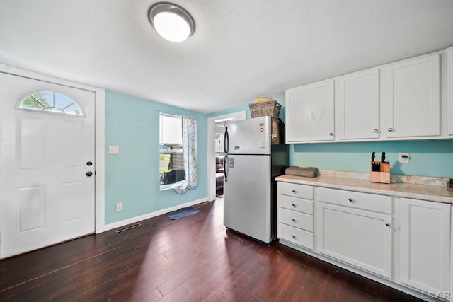 424 W Summit St, Adrian, MI 49221 - kitchen featuring freestanding refrigerator, light countertops, white cabinetry, dark wood-type flooring, and a textured ceiling