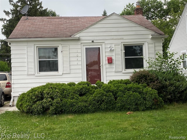 1044 Cloverlawn Ave, Lincoln Park, MI 48146 - view of front of house featuring a chimney, roof with shingles, and a front lawn