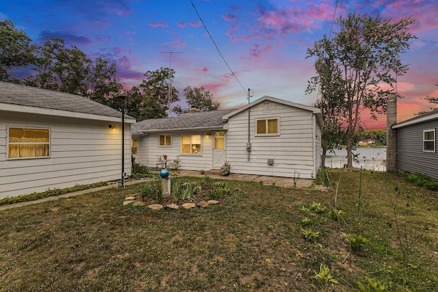 52 S Emerson Lake Dr, Branch, MI 49402 - back of property featuring a lawn and roof with shingles
