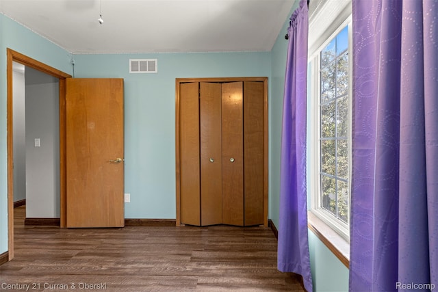 1786 Daisy Ln, Westland, MI 48186 - unfurnished bedroom featuring wood finished floors, multiple windows, and a closet