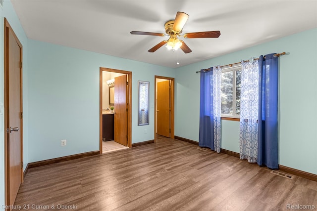 1786 Daisy Ln, Westland, MI 48186 - unfurnished bedroom with wood finished floors, a ceiling fan, and connected bathroom