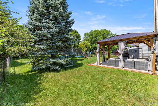 1786 Daisy Ln, Westland, MI 48186 - fenced backyard with a trampoline, outdoor lounge area, a shed, and a gazebo