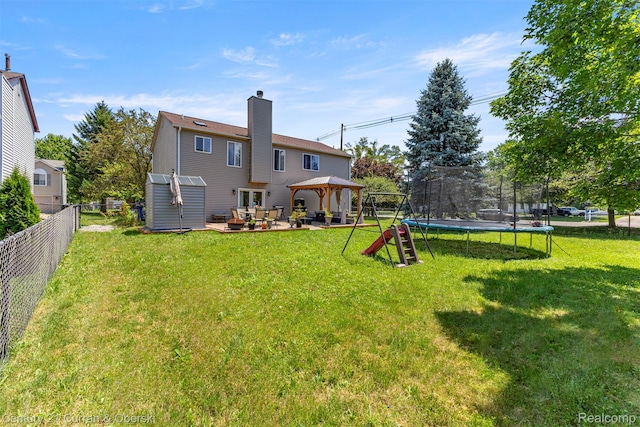 1786 Daisy Ln, Westland, MI 48186 - back of property with a gazebo, a trampoline, a chimney, a patio area, and a fenced backyard