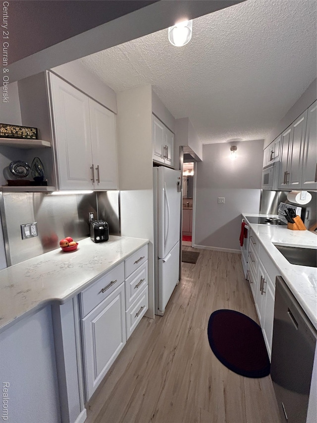 21800 Morley Ave Unit 607, Dearborn, MI 48124 - kitchen with white appliances, light wood-style floors, white cabinetry, a textured ceiling, and open shelves