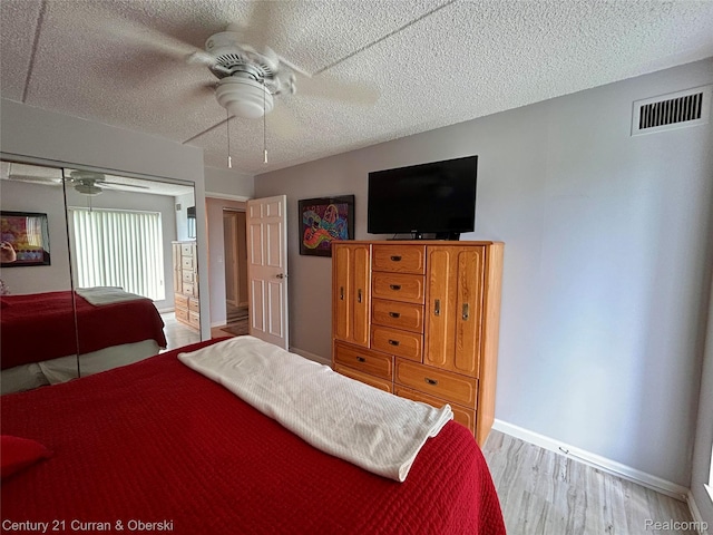 21800 Morley Ave Unit 607, Dearborn, MI 48124 - bedroom featuring a textured ceiling, wood finished floors, a closet, and a ceiling fan