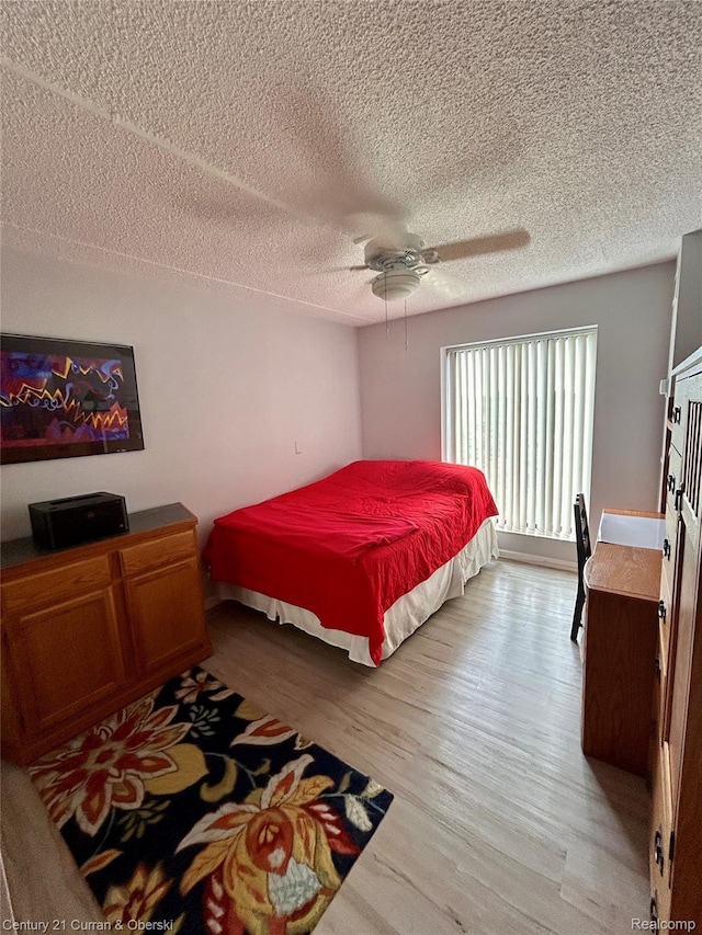 21800 Morley Ave Unit 607, Dearborn, MI 48124 - bedroom with light wood-style flooring, a textured ceiling, and a ceiling fan