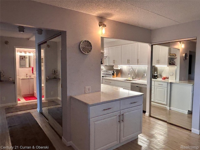21800 Morley Ave Unit 607, Dearborn, MI 48124 - kitchen with appliances with stainless steel finishes, light countertops, white cabinetry, light wood-type flooring, and a textured ceiling
