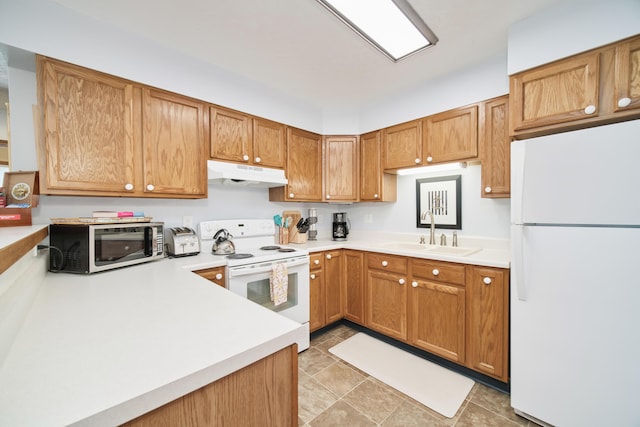 5015 Main St, Onekama, MI 49675 - kitchen featuring white appliances, under cabinet range hood, light countertops, and brown cabinets