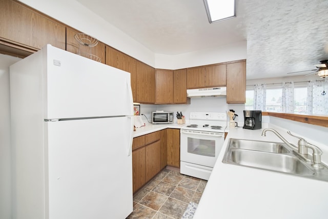 5015 Main St, Onekama, MI 49675 - kitchen featuring white appliances, under cabinet range hood, light countertops, brown cabinets, and a ceiling fan