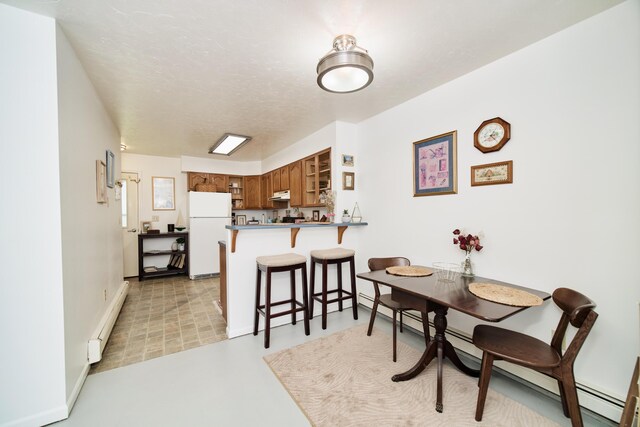 5015 Main St, Onekama, MI 49675 - dining room featuring a baseboard heating unit and baseboards