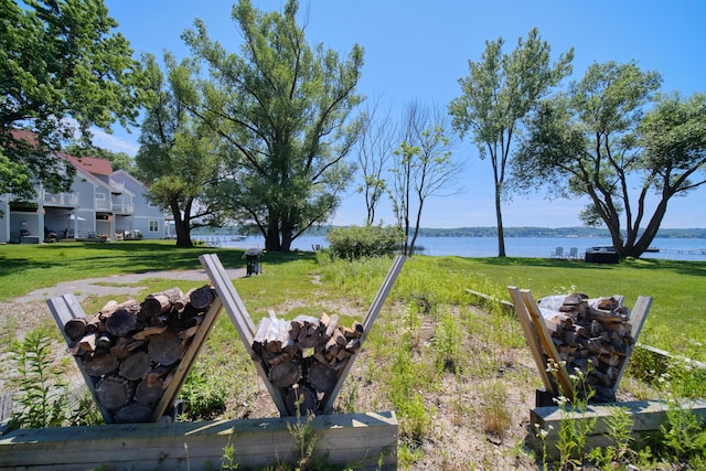 5015 Main St, Onekama, MI 49675 - view of green lawn featuring an outdoor fire pit and a water view