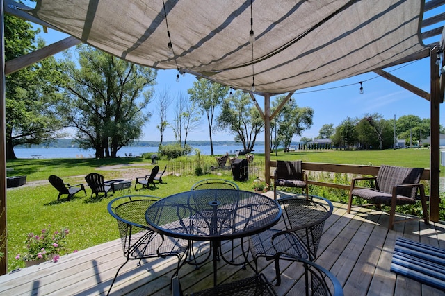 5015 Main St, Onekama, MI 49675 - wooden deck with a water view, a lawn, and outdoor dining space