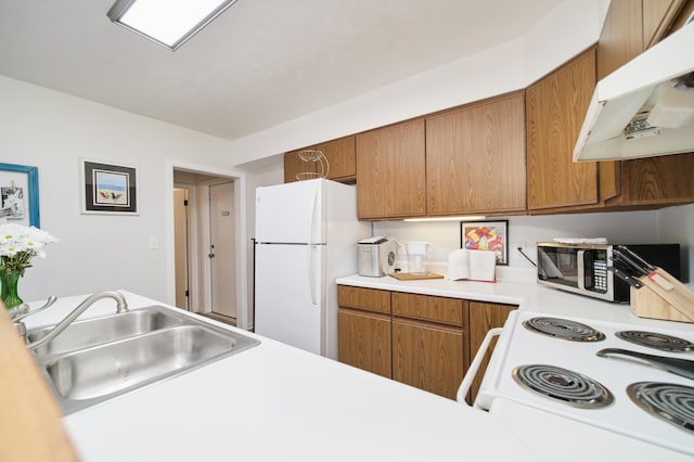 5015 Main St, Onekama, MI 49675 - kitchen featuring under cabinet range hood, white appliances, light countertops, and brown cabinetry