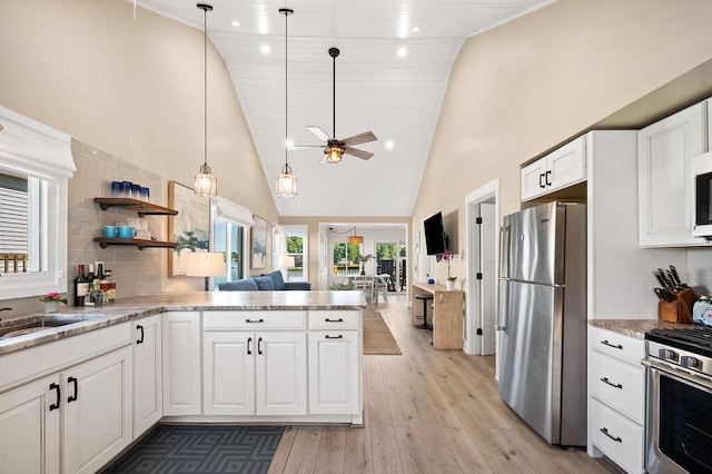 31326 Curran Beach Rd, Dowagiac, MI 49047 - kitchen featuring stainless steel appliances, light wood-style floors, a ceiling fan, white cabinetry, and high vaulted ceiling