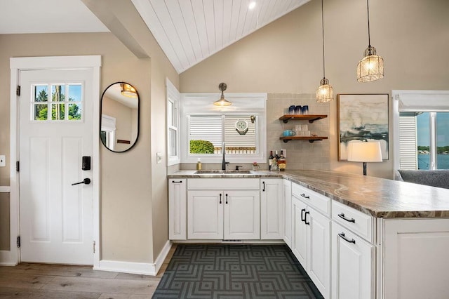 31326 Curran Beach Rd, Dowagiac, MI 49047 - kitchen featuring vaulted ceiling, a peninsula, white cabinetry, dark wood-style floors, and decorative backsplash