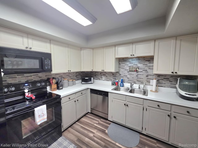 42231 Toddmark Ln, Clinton Township, MI 48038 - kitchen with black appliances, decorative backsplash, light countertops, and wood finished floors