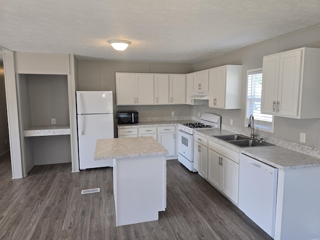 26 Traveler Dr Unit 26, Sparta, MI 49345 - kitchen with white appliances, under cabinet range hood, a center island, dark wood finished floors, and a textured ceiling