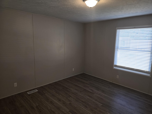 26 Traveler Dr Unit 26, Sparta, MI 49345 - spare room featuring a textured ceiling and dark wood-style flooring