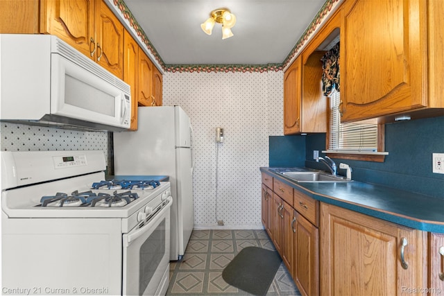 19163 Henry St, Melvindale, MI 48122 - kitchen with white appliances, wallpapered walls, dark countertops, brown cabinetry, and tile patterned floors