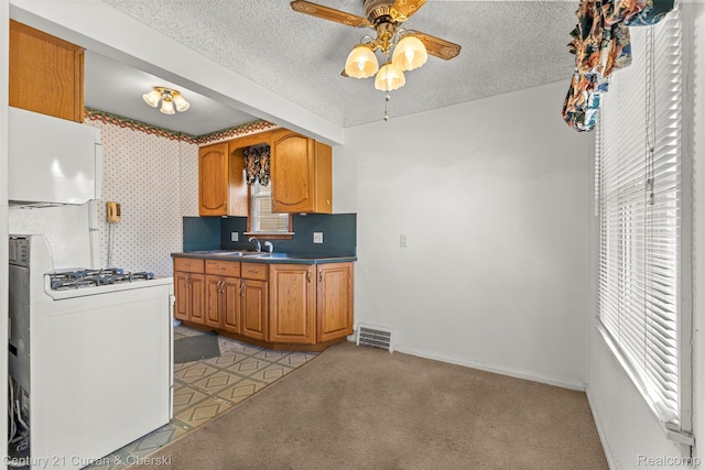 19163 Henry St, Melvindale, MI 48122 - kitchen featuring a ceiling fan, white stovetop, a textured ceiling, dark countertops, and brown cabinets