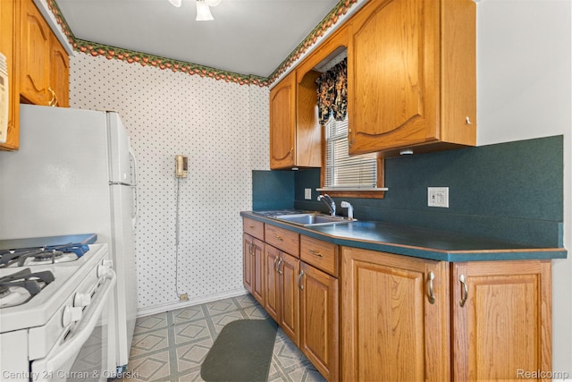 19163 Henry St, Melvindale, MI 48122 - kitchen featuring white range with gas stovetop, dark countertops, and brown cabinets
