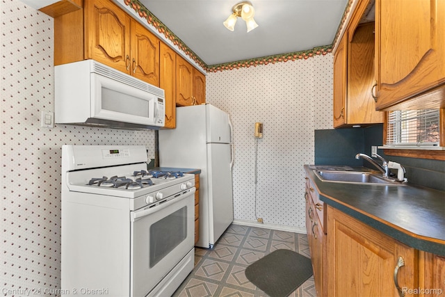 19163 Henry St, Melvindale, MI 48122 - kitchen featuring white appliances, wallpapered walls, dark countertops, and brown cabinetry